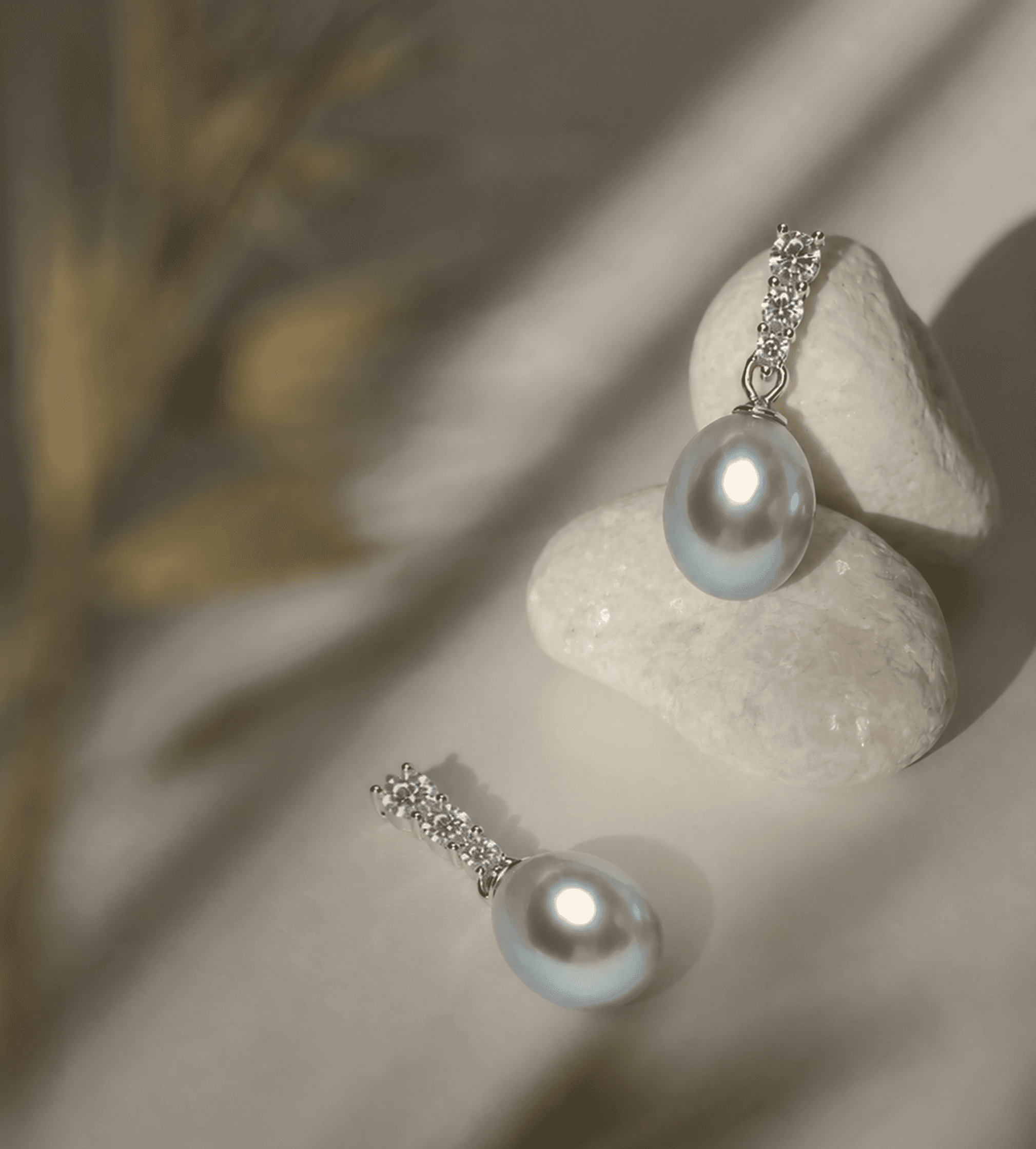 Pearl jewelry arranged on softly lit stones